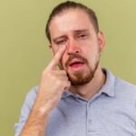 Person experiencing pain in the inner and outer corner of the eye with redness and irritation