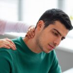 Healthcare professional examining a patient with collarbone pain near the neck and shoulder.