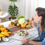 Woman eating a healthy salad with fresh fruits and vegetables to support better blood circulation.