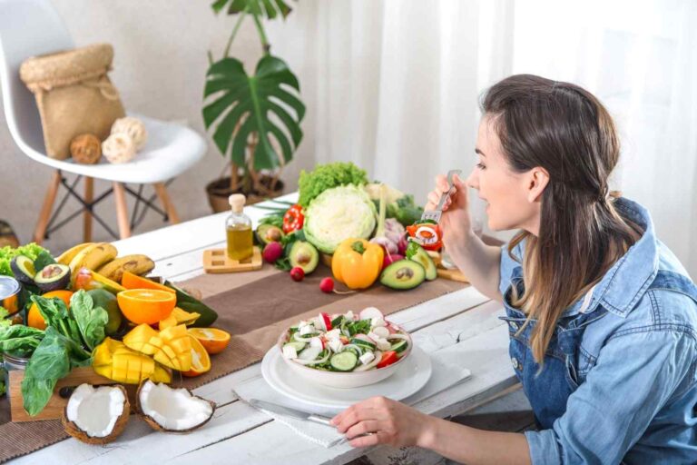 Woman eating a healthy salad with fresh fruits and vegetables to support better blood circulation.