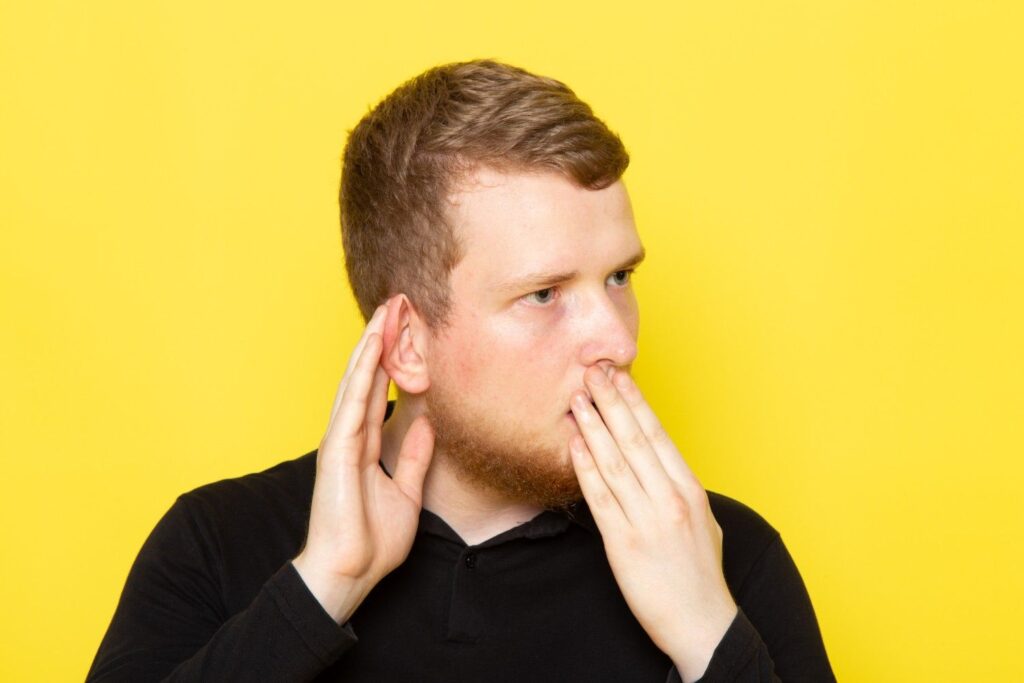Man holding his ear because of a painful pimple inside the ear.