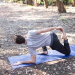 Man performing a thoracic mobility exercise outdoors