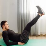 Man performing a leg raise during a lower ab workout at home