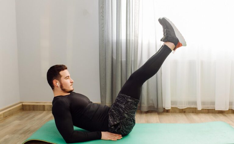 Man performing a leg raise during a lower ab workout at home